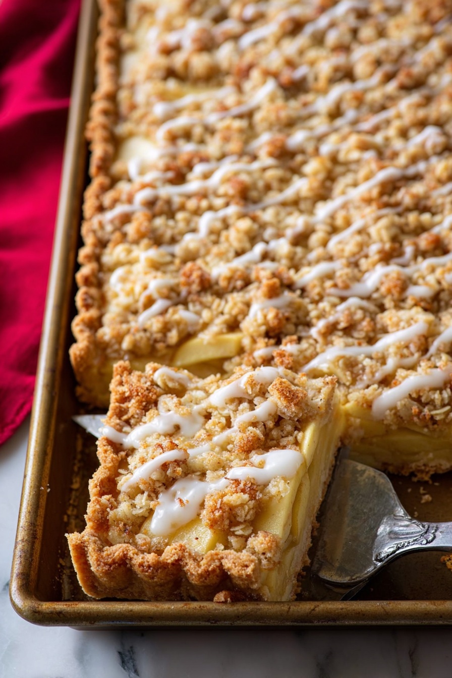 The image shows a close-up of a rectangular apple crumble tart in a metal baking tray. The tart has three layers: a golden brown crust at the bottom with thick edges, a middle layer of soft apple slices with a light yellow color, and a top layer of crumbly, golden oat streusel sprinkled unevenly, drizzled with white icing glaze. One slice is lifted with a silver pie server, revealing the layers clearly. The background is a white marbled surface with a red cloth partially visible on the left side. Photo taken with an iphone --ar 2:3 --v 7