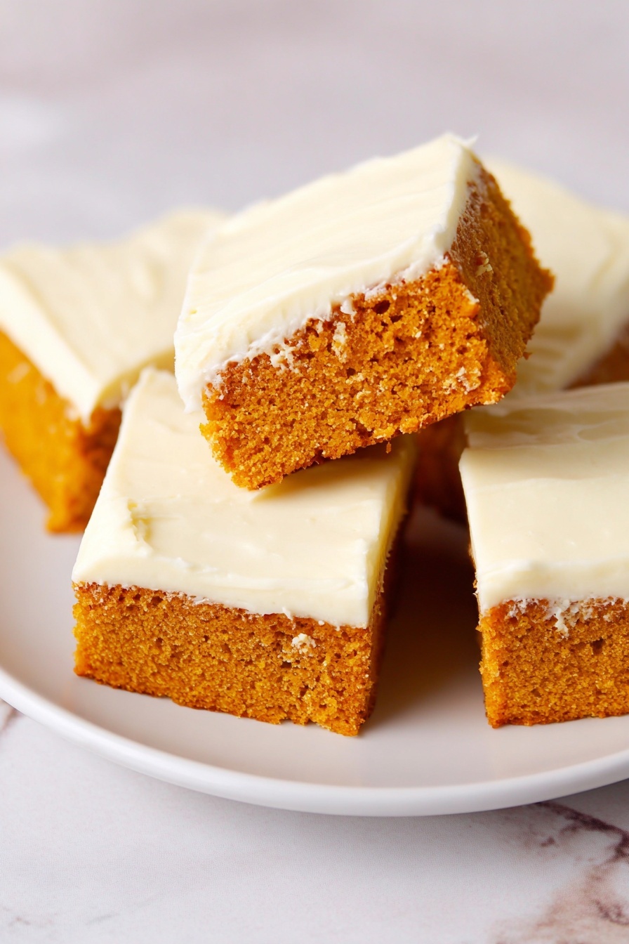 The image shows four rectangular pieces of an orange-colored cake on a white plate placed on a white marbled texture. Each piece has two layers: a thick, moist, and textured orange cake base on the bottom and a smooth, creamy white frosting layer on top. One piece is tilted up, showing the side view of the two layers clearly, while the other three pieces lay flat on the plate, displaying the smooth frosting tops. The frosting has a soft, slightly swirled texture. Photo taken with an iphone --ar 2:3 --v 7