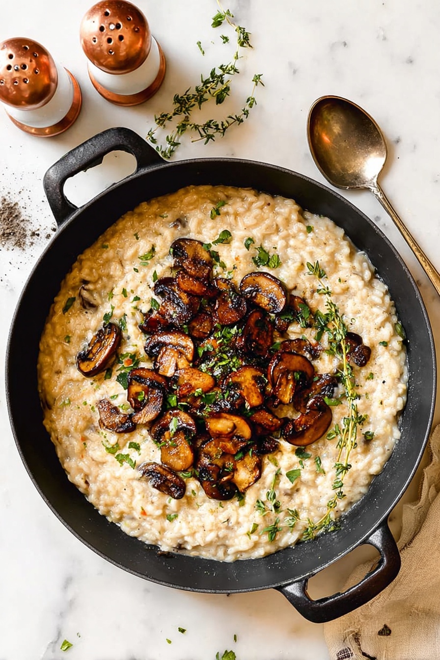 In a black pot with handles, there is a thick creamy risotto spread evenly as the base layer, light beige in color with small, visible grains. On top, there is a generous heap of cooked brown mushrooms, sliced and browned, placed in the center. Small green herb leaves and sprigs of fresh thyme are scattered over the mushrooms and risotto, adding spots of green. Around the pot, small bits of chopped parsley are sprinkled on a white marbled surface. A shiny silver spoon rests nearby, and two copper and white salt and pepper mills stand in the background. photo taken with an iphone --ar 2:3 --v 7