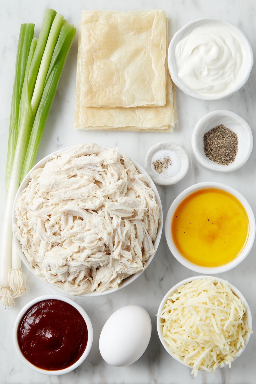 Flat lay of cooked and shredded chicken, a smooth mound of softened cream cheese, a small white bowl of plain Greek yogurt, a small white bowl filled with vibrant orange buffalo sauce, a small pile of shredded mozzarella cheese, fresh whole scallions with green stalks and white bulbs, a small white bowl containing fine garlic powder, a small white bowl with ground black pepper, a small white bowl with fine salt, two rectangular sheets of thawed puff pastry, and a single whole egg with a clean shell, all arranged in perfect symmetry on a clean white marble surface, soft natural light, photo taken with an iPhone, professional food photography style, fresh ingredients, white ceramic bowls, no bottles, no duplicates, no utensils, no packaging --ar 2:3 --v 7 --p m7354615311229779997