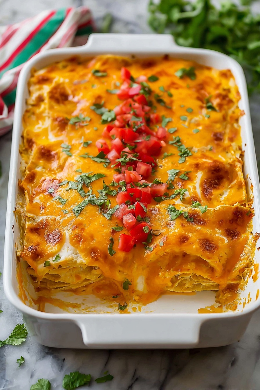 A white rectangular baking dish filled with a layered cheesy casserole. The top layer is melted bright orange cheese with some areas browned slightly. A line of finely chopped red tomatoes and green herbs runs down the center of the dish as a garnish. The edges of the casserole show some of the melted cheese oozing over the side. The dish sits on a white marbled surface with some green leaves and a cloth with green and red stripes in the background. photo taken with an iphone --ar 2:3 --v 7