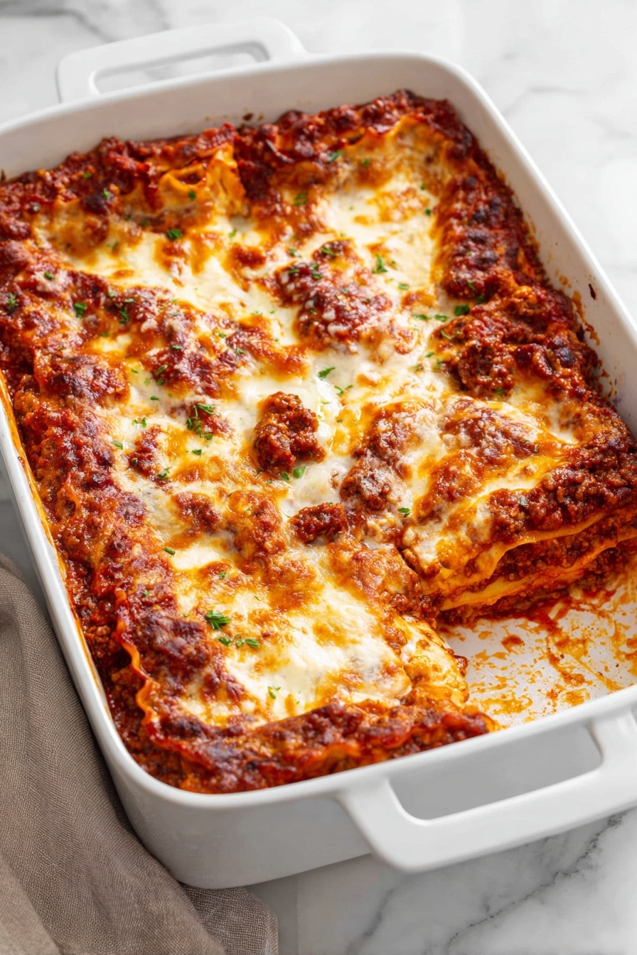 The dish is a baked lasagna in a white rectangular baking dish with two handles on each side. It has multiple layers visible from the missing portion: a base layer of rich, red tomato sauce mixed with ground meat and soft pasta sheets, followed by creamy melted cheese layers that are golden and slightly browned on top. The surface is bubbling with patches of browned cheese and sauce, with some sauce residue along the edges. The dish sits on a white marbled surface with a neutral cloth napkin nearby. photo taken with an iphone --ar 2:3 --v 7