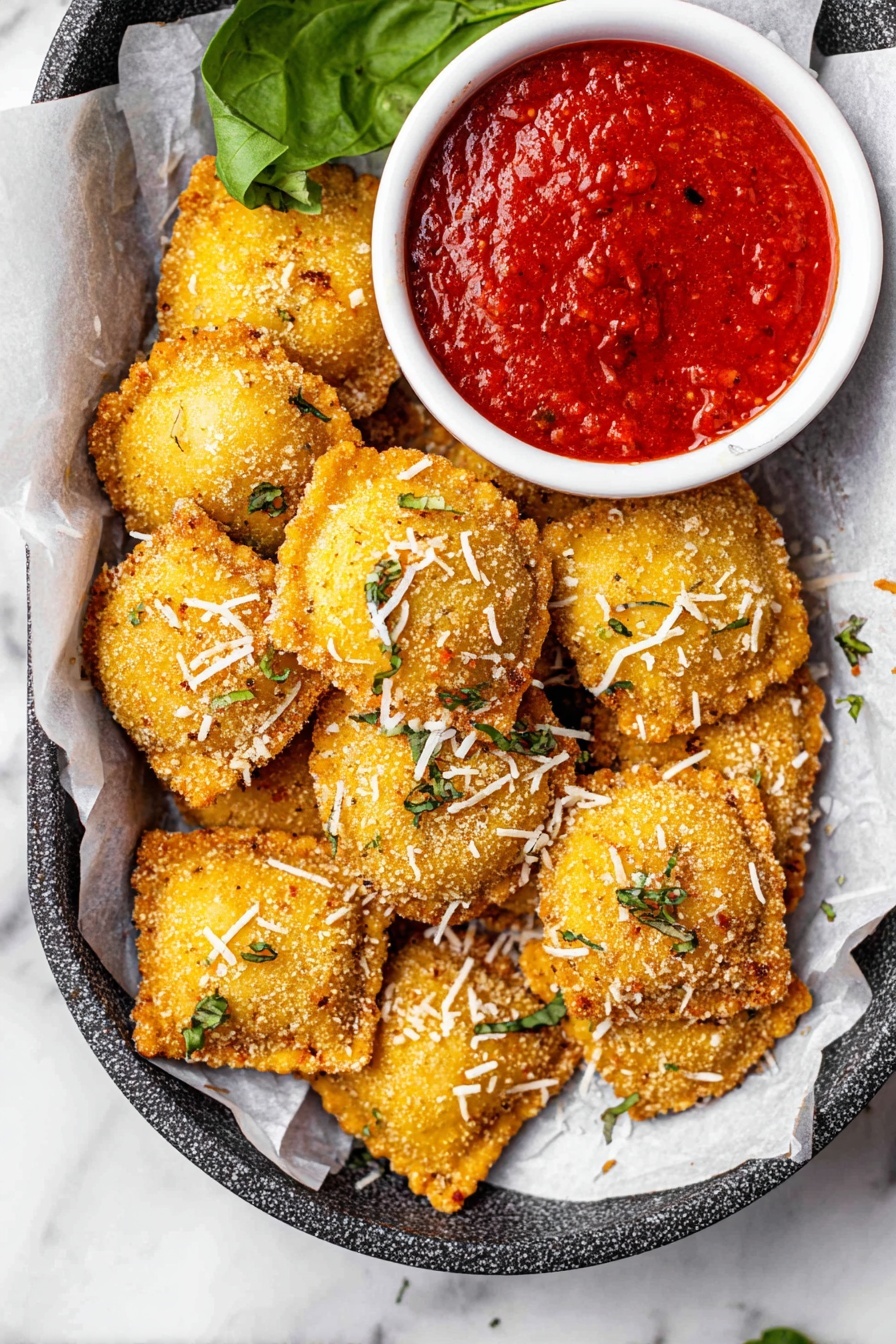 A group of golden brown, round fried bites with a crunchy texture are laid out on white parchment paper inside a metal tray with a rough dark gray surface. The bites are sprinkled with small shreds of white cheese and tiny green herb pieces scattered on top. On the right, a small white bowl filled with thick, chunky, bright red dipping sauce sits next to the fried bites. There are a few green spinach leaves on the upper left side adding a fresh touch. The whole setup rests on a white marbled surface. photo taken with an iphone --ar 2:3 --v 7
