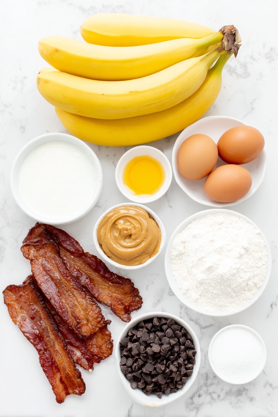 Flat lay of a bunch of three large ripe bananas, a small mound of light brown sugar, two whole uncracked brown eggs, a small pile of glossy raw bacon slices, a heaping handful of dark chocolate chips, a small white ceramic bowl of creamy peanut butter, a small white ceramic bowl of golden honey, a small white ceramic bowl of powdered sugar, a small white ceramic bowl of vegetable oil, a small white ceramic bowl of full-fat sour cream, a small white ceramic bowl of granulated sugar, a small white ceramic bowl of all-purpose flour, a small white ceramic bowl of baking soda, a small white ceramic bowl of salt, placed on a clean white marble surface, soft natural light, photo taken with an iPhone, professional food photography style, fresh ingredients, white ceramic bowls, no bottles, no duplicates, no utensils, no packaging --ar 2:3 --v 7 --p m7354615311229779997
